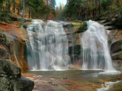 Amazing Waterfall in Forest over Rusty Rocks