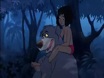 Mowgli riding on Baloo's back in the jungle at night from The Jungle Book 2.