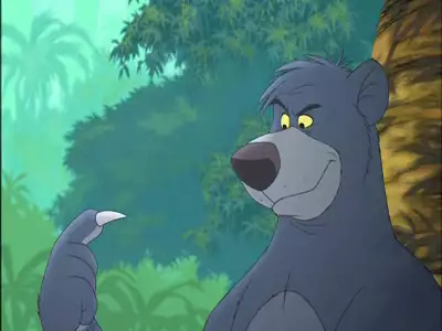 Baloo playfully examining his claw with a grin in The Jungle Book 2.