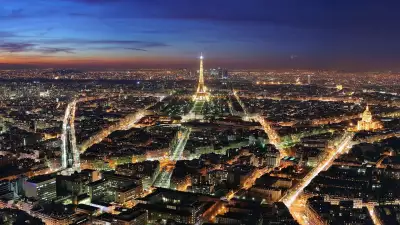 Aerial view of Paris at night, with the Eiffel Tower illuminated