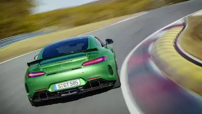 Green Mercedes AMG GT R gracefully speeding on the road, showcasing a perfect blend of speed and style
